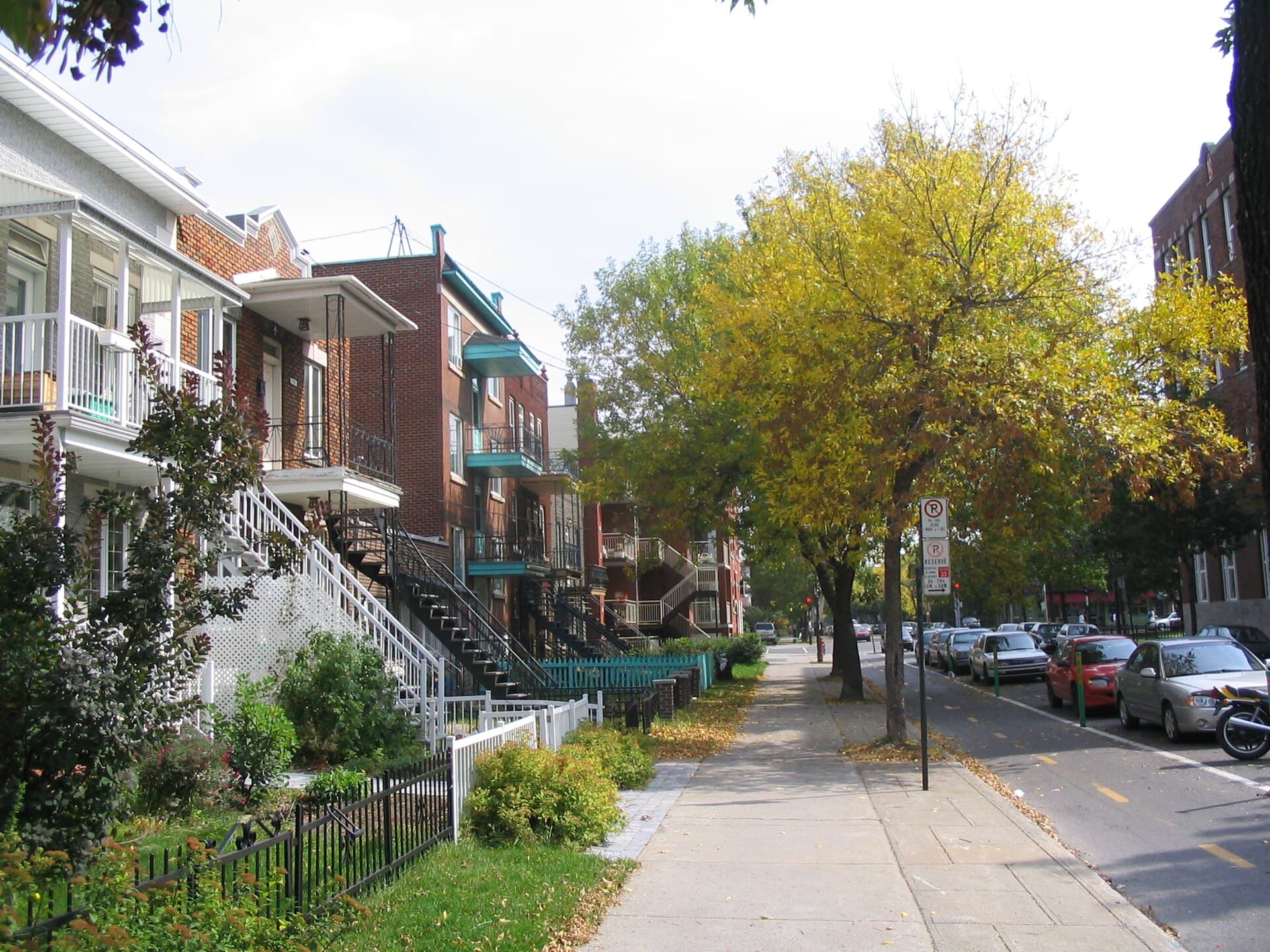 Rue résidentielle bordée de plex avec escaliers extérieurs, à Villeray